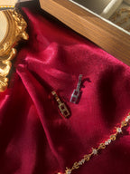 Bracelet extender clip on red fabric with a decorative gold frame.