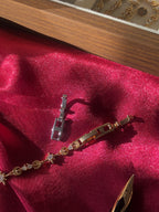 Gold bracelet with star-shaped charms on a red fabric background