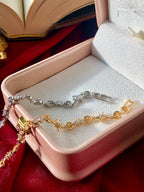 Gold and silver tennis bracelet in a jewelry box on a red fabric background
