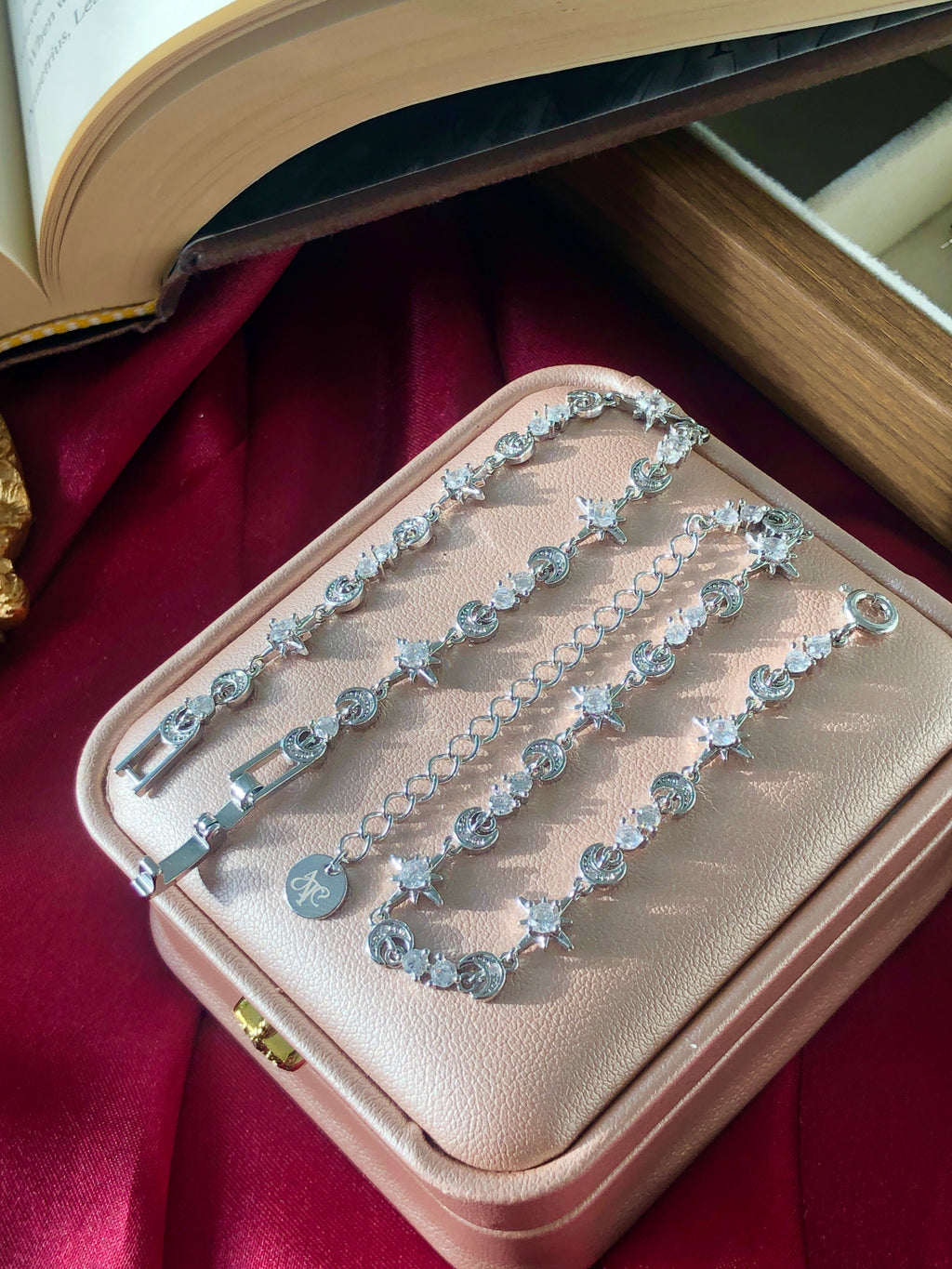 Set of silver tennis bracelets on a jewelry box on a red fabric background