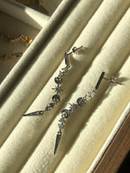 Sterling Silver earrings with star and moon designs on a beige cushion