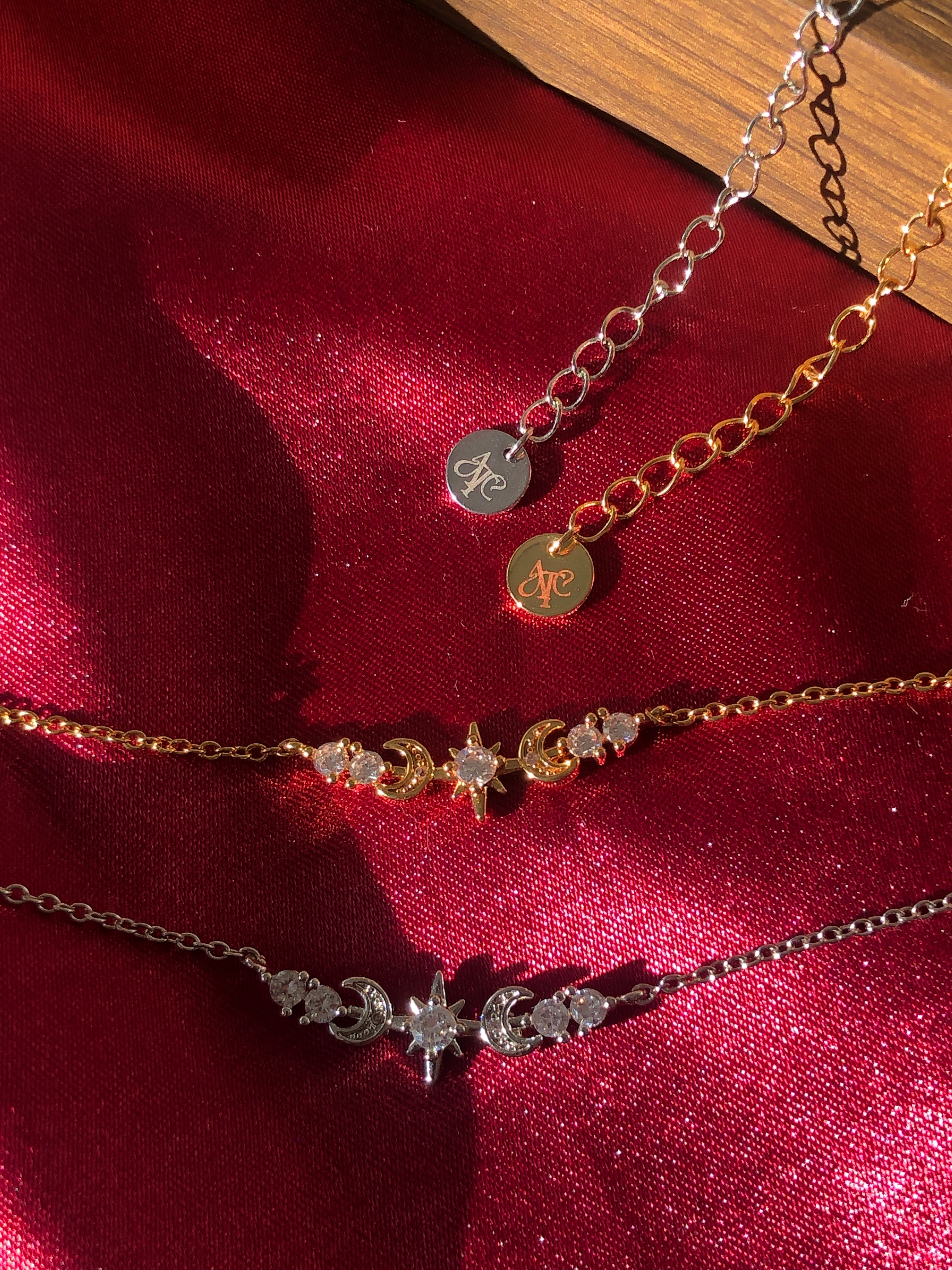 Sterling Silver and 18K Gold Star necklaces on a red fabric background