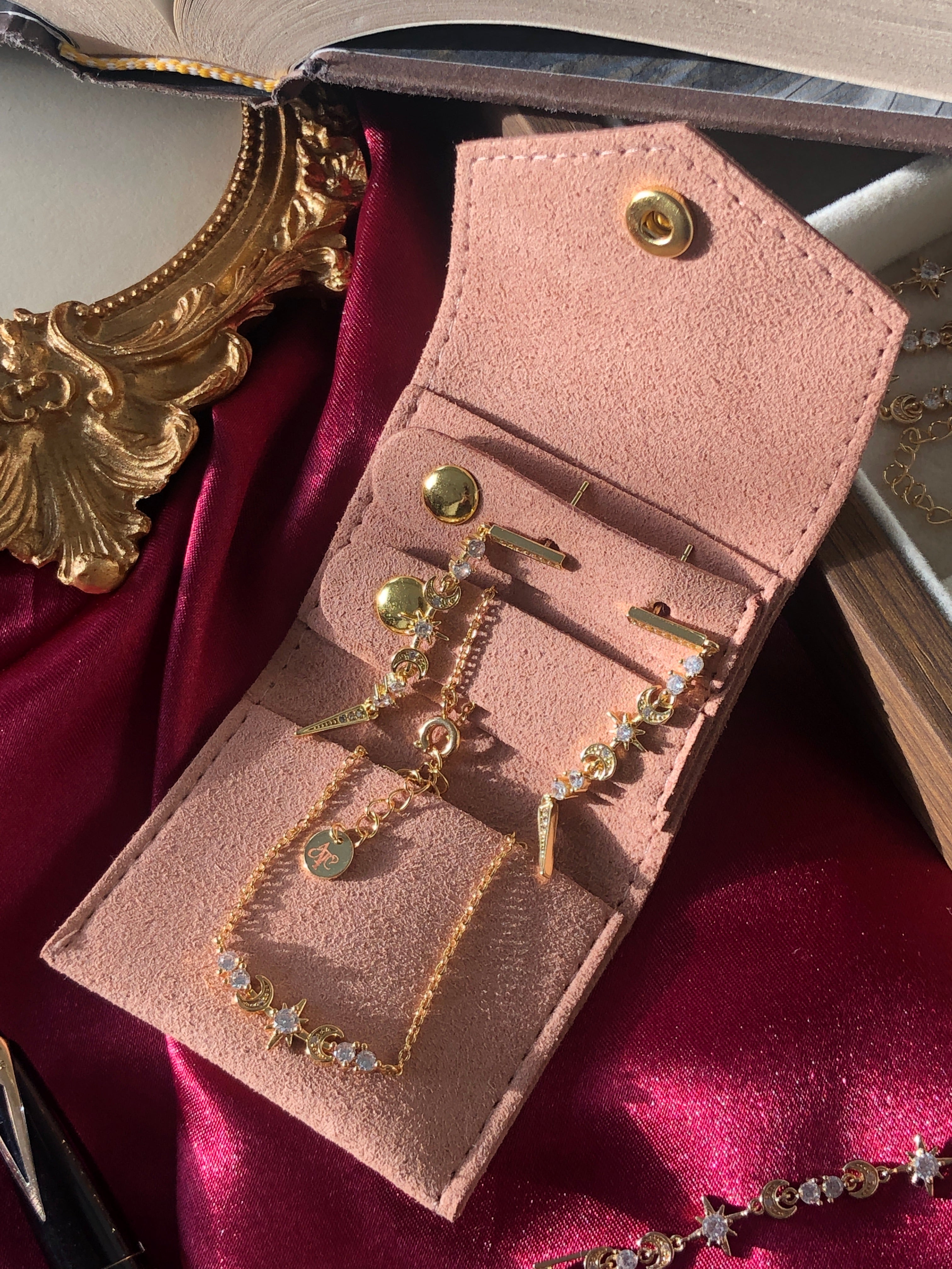 Travel sized light pink pouch on a red satin background