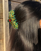 Decorative hair clip on a person's hair with a wooden background
